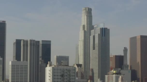 AERIAL: Acercarse al centro de Los Ángeles, California Skyline en la hermosa luz del sol, cielo azul , — Vídeos de Stock