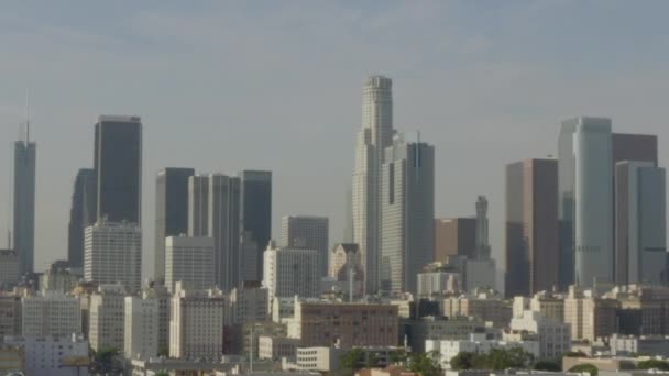 AERIAL: széles kép Los Angeles belvárosában, Kalifornia Skyline gyönyörű napsütésben, kék ég, — Stock videók