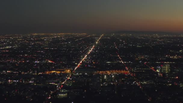 AERIAL: 180 Stopień widok na Hollywood Hills w nocy z widokiem na centrum Los Angeles, City Lights — Wideo stockowe