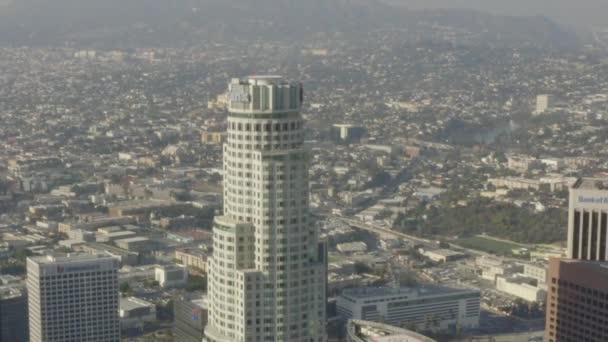 AERIAL: Szerokie ujęcie US Bank Skyscraper Top, Heli Pad w centrum Los Angeles, Kalifornia z pięknym słońcem, błękitne niebo, — Wideo stockowe