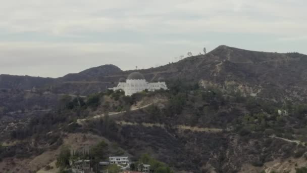 AERIAL: Observatório Griffith longe com vista sobre Hollywood Hills em Daylight, Los Angeles, Califórnia, Nublado — Vídeo de Stock