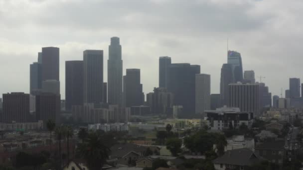 AERIAL: Hacia el centro de Los Ángeles, California sobre la autopista ocupada con palmeras, tráfico, nublado — Vídeo de stock