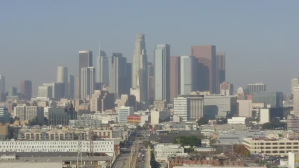 AERIAL: Hacia el centro de Los Angeleso sobre el río LA con construcciones y coches, tráfico, luz del día — Vídeo de stock