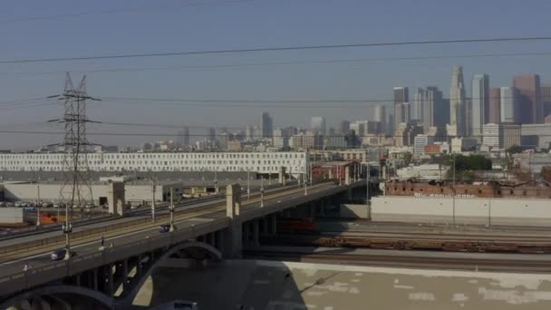 AERIAL: LA River, Treinsporen met het centrum van Los Angeles op de achtergrond, Zonlicht — Stockvideo