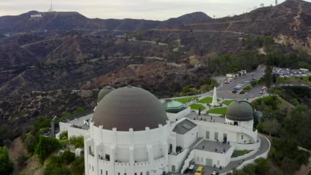 AERIAL: Close Up of Griffith Observatory com Hollywood Hills em Daylight, Los Angeles, Califórnia, Nublado — Vídeo de Stock