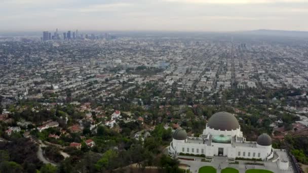 AERIAL: Sopra l'Osservatorio Griffith con Los Angeles, California Skyline sullo sfondo alla luce del giorno, Nuvoloso — Video Stock