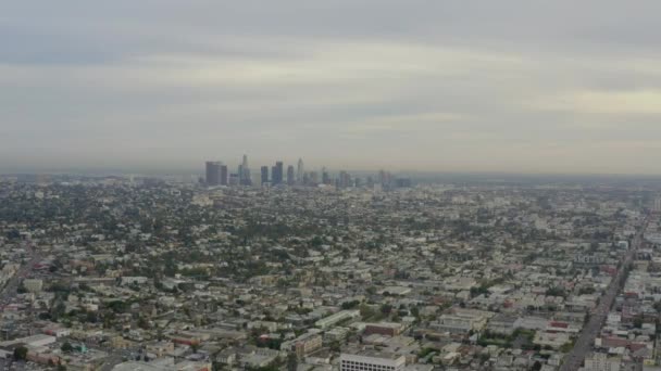 AERIAL: Vlucht over Los Angeles, Californië met Skyline op de achtergrond, bewolkt bij daglicht, — Stockvideo
