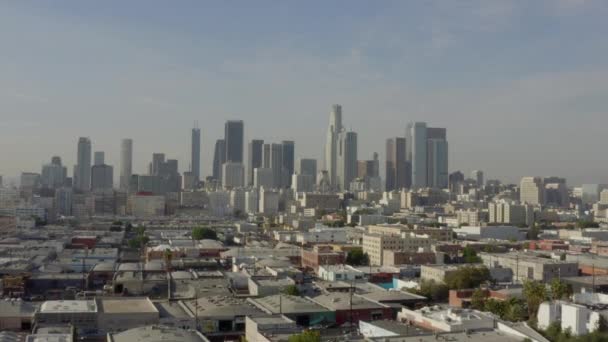 AERIAL: Hacia el centro de Los Ángeles, California Skyline en la hermosa luz del sol, cielo azul, — Vídeo de stock