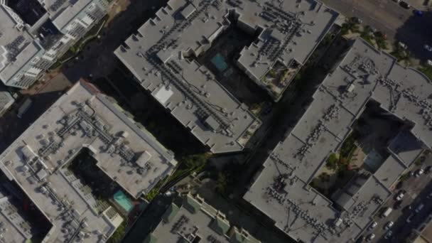 AERIAL: Birds Eye Vista sobre las calles del centro de Los Ángeles, California con coches, tráfico y tejados, piscinas, luz del día — Vídeo de stock