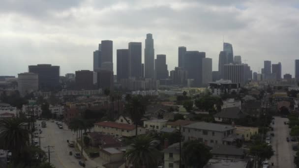 AERIAL: Hacia el centro de Los Ángeles, California sobre la autopista ocupada con palmeras, tráfico, nublado — Vídeos de Stock