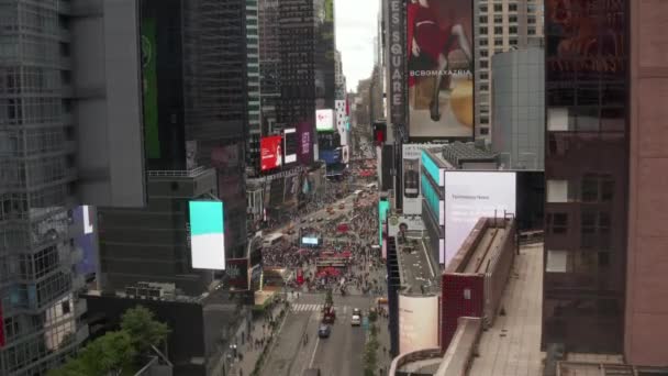 AERIAL: Look over Times Square heart of New York City at Daylight with crowd of people and heavy car traffic advertisements and police — Stock Video