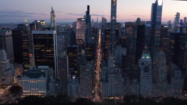 AERIAL: Manhattan Skyline por la noche con luces parpadeantes de la ciudad de Nueva York sobre Central Park — Vídeos de Stock