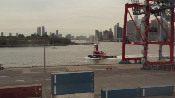 AERIAL: Rött skepp, Båt passerar i New York City hamnen på molnig dag — Stockvideo