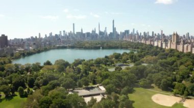 Güneşli yaz gününde, New York 'ta göllü ve Manhattan Skyline' lı güzel Central Park manzarası 
