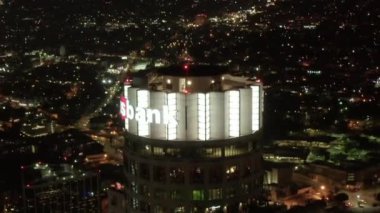 Los Angeles şehir merkezindeki Amerikan Bankası Kulesi gökdeleninin yakın görüntüsü, gece parlayan şehir ışıkları.