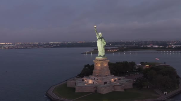 AERIAL: Krążąca Statua Wolności pięknie oświetlona wczesnym rankiem Nowy Jork — Wideo stockowe