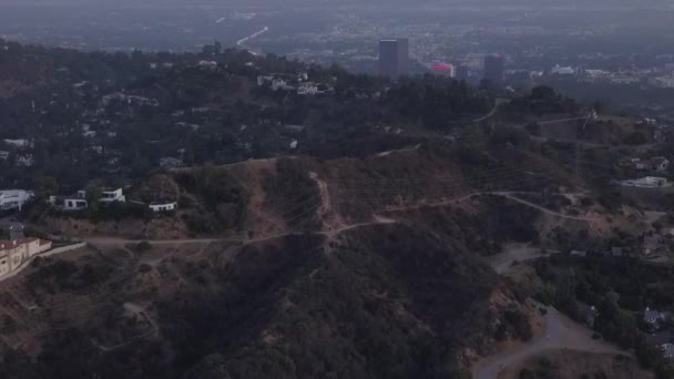AERIAL: Über Hollywood Hills bei Sonnenaufgang mit Blick auf Hügel und Tal und Hochspannungsleitungen in Los Angeles — Stockvideo