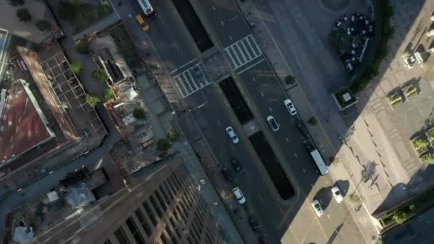 AERIAL: Epic slow lowering and circiling birds eye View over Downtown Los Angeles California in beautiful Sunrise Light with view of skyscraper rooftop and car traffic passing — Stock video