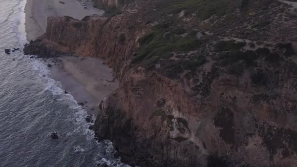 AERIAL: vuelo sobre Malibú, California vista de la playa Shore Line Paficic ocean al atardecer con acantilado de montaña — Vídeos de Stock