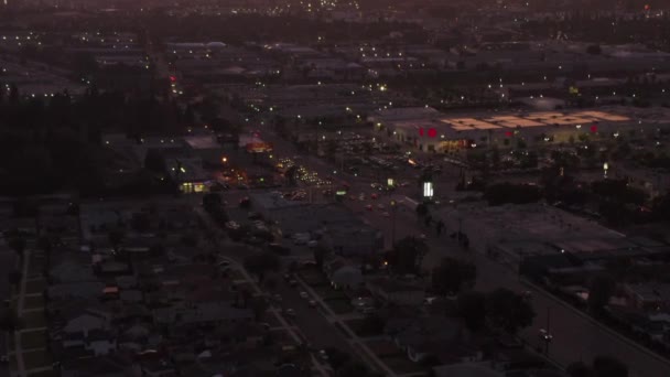 AERIAL: View of Culver City, Los Angeles, California traffic, interesction at dusk with car traffic passing and parking lot — ストック動画