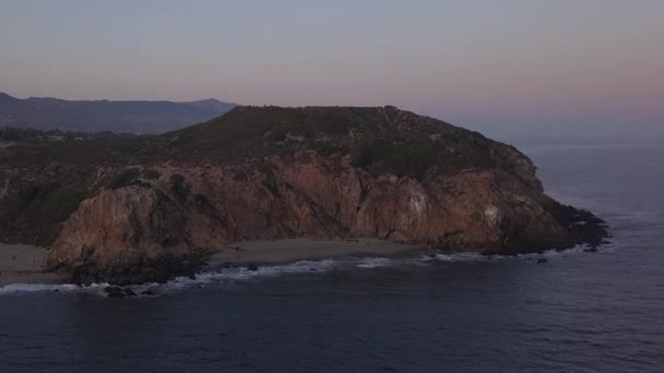 AERIAL: Політ через Малібу, Каліфорнія Вид на берегову лінію Пафік океан на заході сонця з гірською скелею — стокове відео