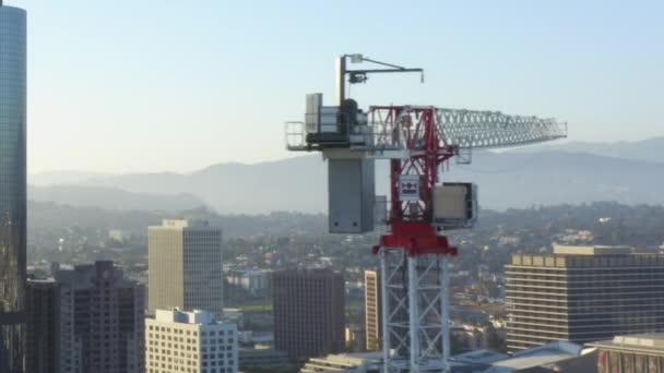 AERIAL: Närbild av byggarbetsplats Skyskrapa kran i centrala Los Angeles, Kalifornien Skyline på vacker blå himmel och solig solig känsla dag — Stockvideo