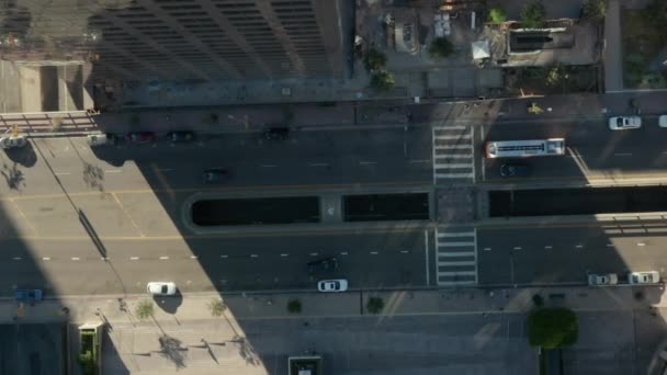 AERIAL: slow lower birds eye View flight over Downtown Los Angeles California Grand Avenue in beautiful Sunrise Light with view of skyscraper roof and car traffic passing — 图库视频影像