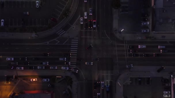 AERIAL: Birds eye view of Culver City, Los Angeles, California traffic夕暮れ時の交差点車の通行と駐車場 — ストック動画