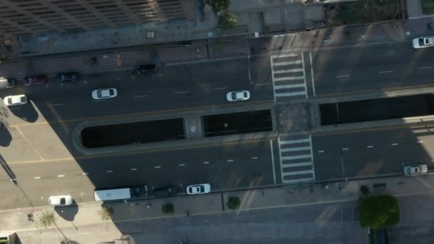 AERIAL: slow uplifting birds eye View flight over Downtown Los Angeles California Grand Avenue in beautiful Sunrise Light with view of skyscraper roof and car traffic passing — 图库视频影像