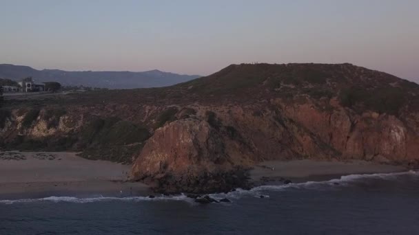 AERIAL: lot nad Malibu, Kalifornia widok na plażę Shore Line Paficic ocean o zachodzie słońca z urwiskiem górskim — Wideo stockowe