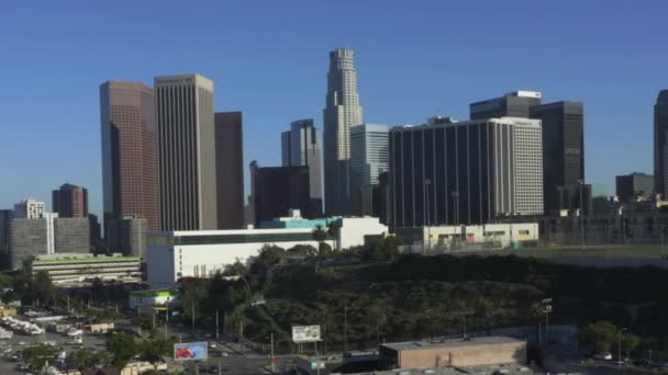 AERIAL: Voando para longe do centro de Los Angeles, Califórnia Skyline no céu azul bonito e dia ensolarado — Vídeo de Stock