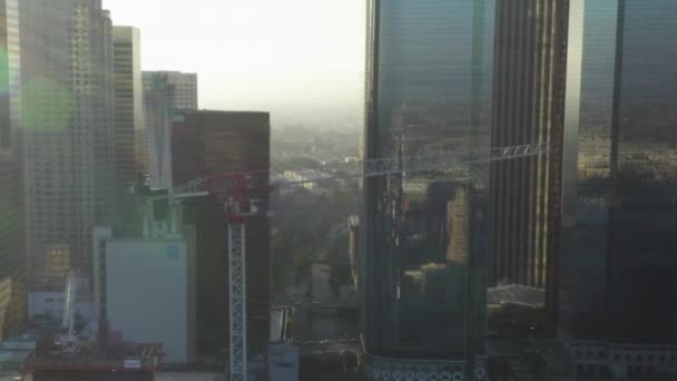 AERIAL: Repülés felé építési telek felhőkarcoló Los Angeles belvárosában, Kalifornia Skyline gyönyörű kék ég és napos nap — Stock videók