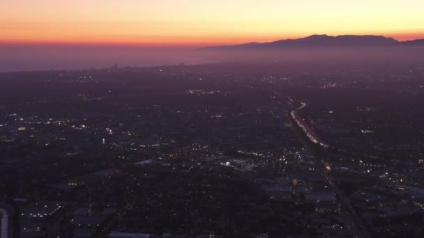 AEREO: Ampia vista di Los Angeles, California verso il meraviglioso oceano da Culver City al tramonto, notte con cielo viola e luci della città incandescente — Video Stock