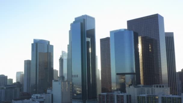 AERIAL: Volando hacia el centro de Los Ángeles, California Skyline con una mirada a las casas y el tráfico callejero en el hermoso cielo azul y el día soleado — Vídeo de stock