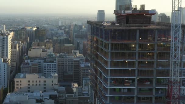 AERIAL: Voando em direção ao arranha-céu do canteiro de obras no centro de Los Angeles, Califórnia Skyline no céu azul bonito e dia ensolarado — Vídeo de Stock