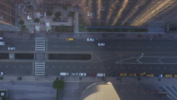 AERIAL: Slow Birds eye Ver voo sobre Downtown Los Angeles California Grand Avenue na bela Sunrise Light com trânsito de carro passando — Vídeo de Stock