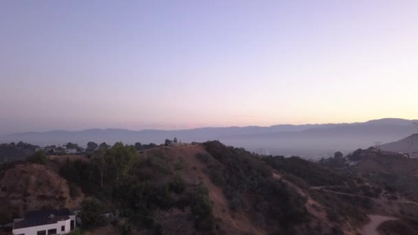 AERIAL: Sobre Hollywood Hills at Sunrise com vista para as colinas e o vale em Los Angeles vista — Vídeo de Stock