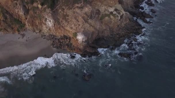 AERIAL: полет над Малибу, Калифорния, вид на пляж Shore Line Paficic океан на закате с горной скалой — стоковое видео