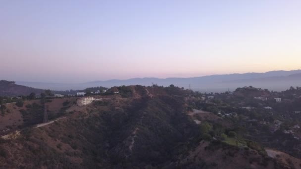 AERIAL: over Hollywood Hills at Sunrise kilátással a hegyekre és a völgyre Los Angeles nézet — Stock videók