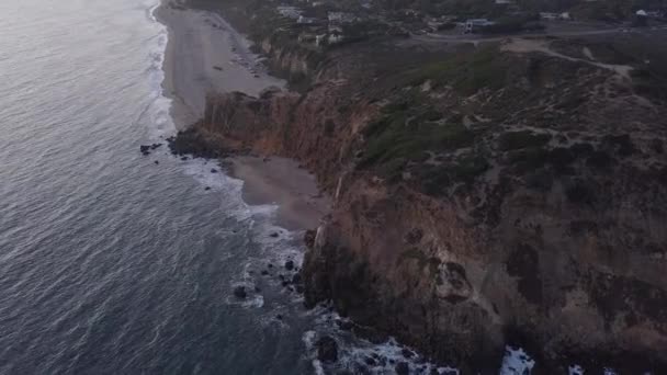 AERIAL: voo sobre Malibu, Califórnia vista da praia Shore Line Oceano Paficic ao pôr do sol com penhasco de montanha — Vídeo de Stock