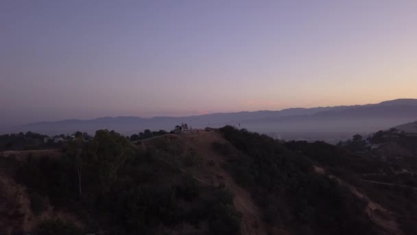 AERIAL: over Hollywood Hills at Sunrise kilátással a hegyekre és a völgyre Los Angeles nézet — Stock videók