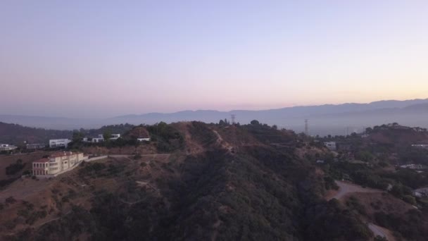 AERIAL: Sobre Hollywood Hills at Sunrise com vista para as colinas e o vale em Los Angeles vista — Vídeo de Stock