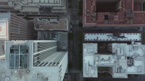 AERIAL: Slow Birds Eye超高層ビルの屋根と車の交通量が通過する景色を望む美しい日の出の光で、ロサンゼルスダウンタウンの上空のフライトを見る — ストック動画