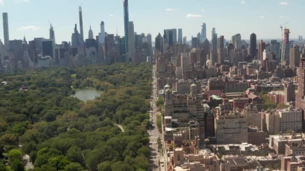 AERIAL:晴れた夏の日に中央公園の美しいニューヨーク市の通りを飛ぶ — ストック動画