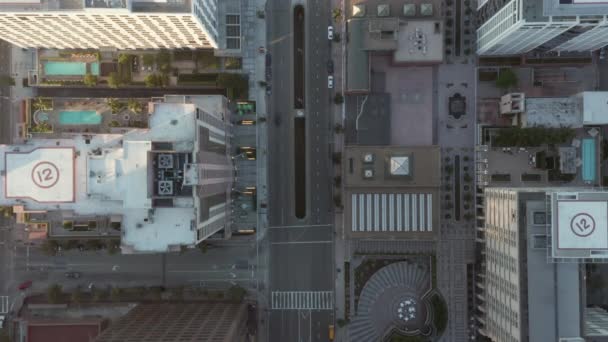 AERIAL: Slow Birds eye View flight over Downtown Los Angeles California in beautiful Sunrise Light with view of skyscraper roofops and car traffic passing — Wideo stockowe