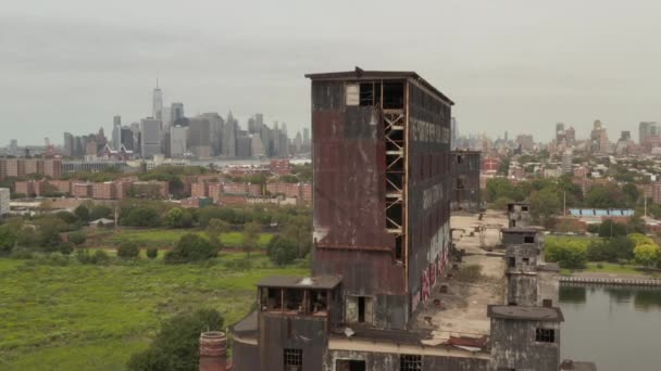 AERIAL: Sobre el viejo almacén con el horizonte de la ciudad de Nueva York en segundo plano en un día nublado gris — Vídeos de Stock