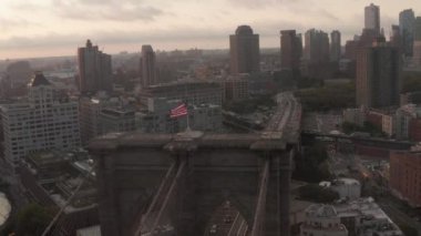 Brooklyn Köprüsü üzerinde Amerikan bayrağı ve sisli New York City Skyline ile yakın uçuş 
