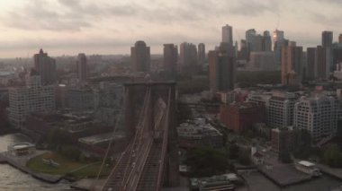 Brooklyn Köprüsü üzerinde sabah güneşiyle Brooklyn 'e doğru hareket eden bir araba trafiği var. 