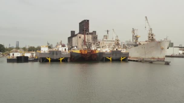 AERIAL: 구름낀 회색 날에 뉴욕도 크에 있는 Rusty old Cargo Ship and Warehouse in the Docks of New York City — 비디오