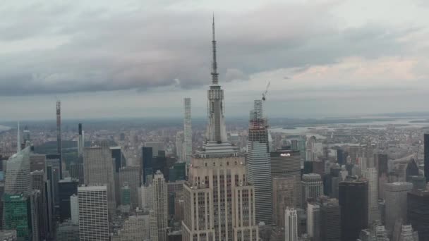 Epico sguardo sull'Empire State Building di Manhattan circondato da falci nella trafficata città durante la giornata nuvolosa — Video Stock